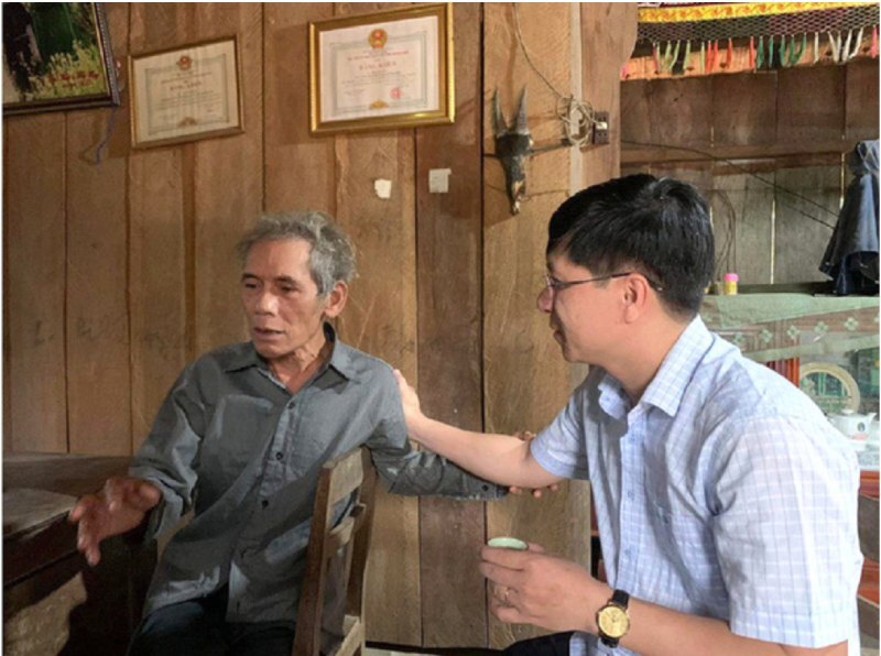 Ông Đặng Minh Thảo (bên phải) trò chuyện với người có uy tín ở nóc Ông Đến, vận động người dân xuống núi - Ảnh: M.T